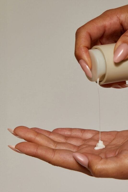 A dollop of hydrating moisturizer on a palm, demonstrating the texture used to seal hydration and protect the skin barrier.